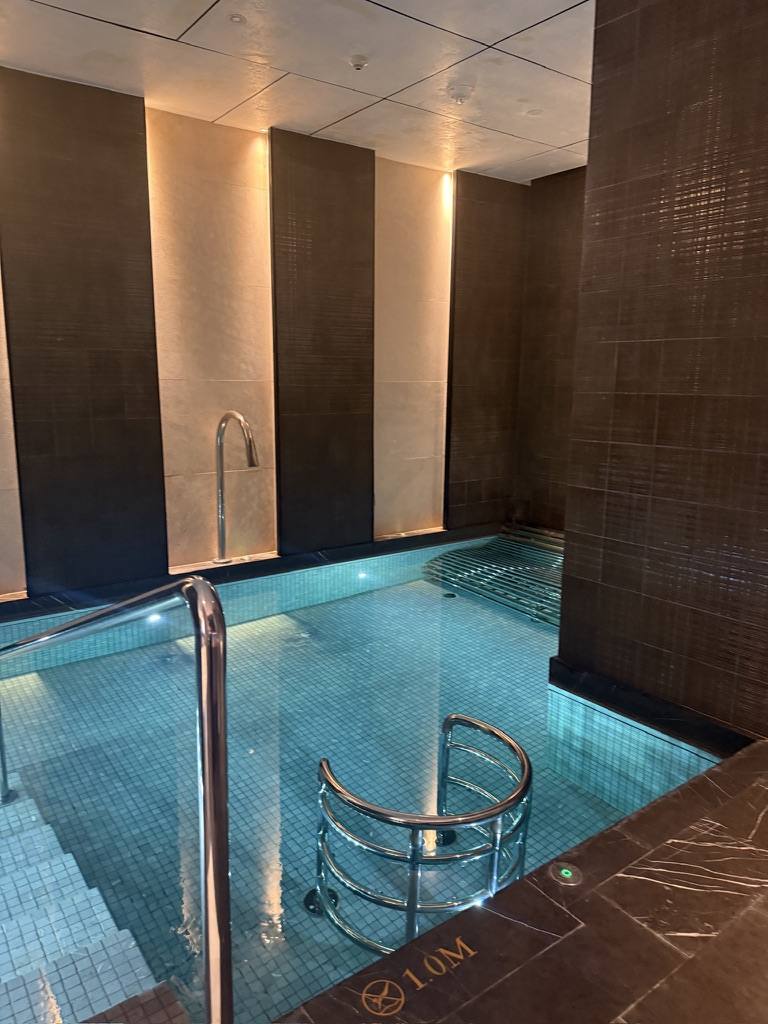 A tiled indoor vitality pool with steps down into it