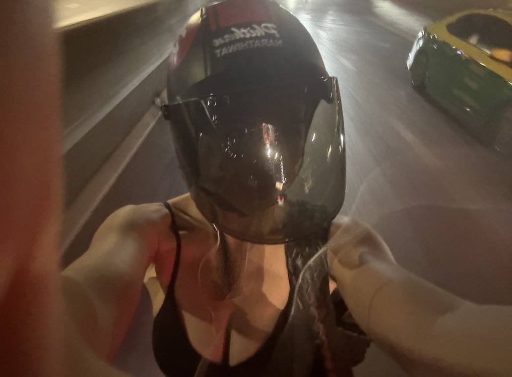 Lauren in a moto-taxi helmet, Bangkok at night
