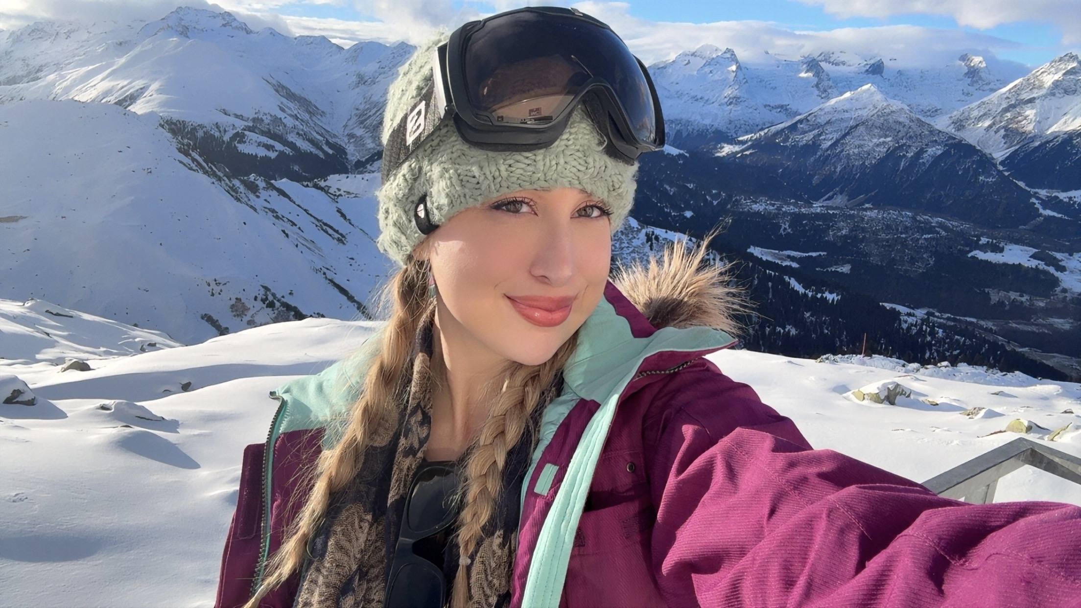Goggles up on the mountain, snow behind