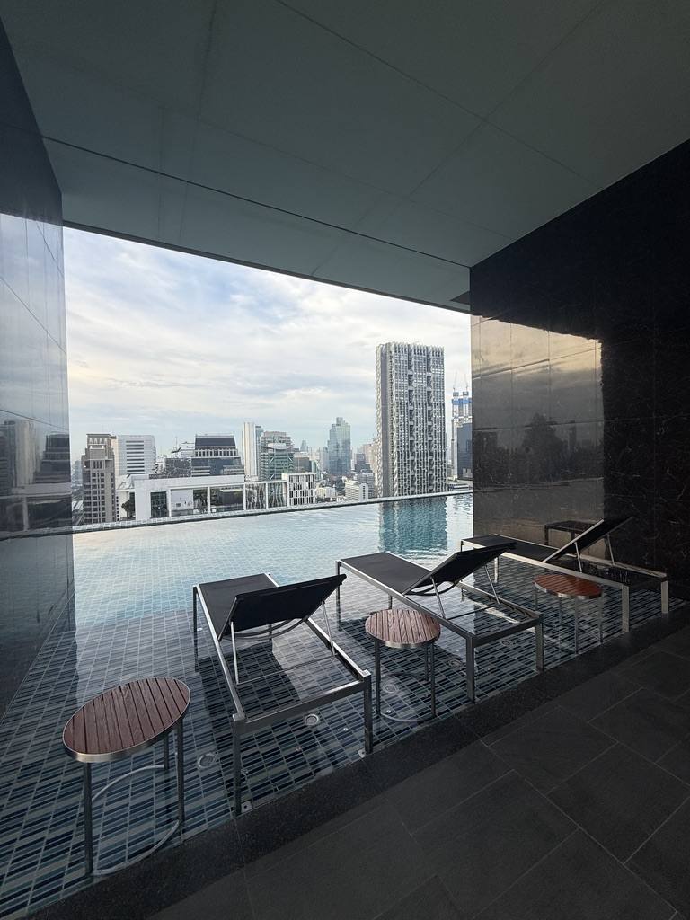 A rooftop sky pool with loungers and the city beyond