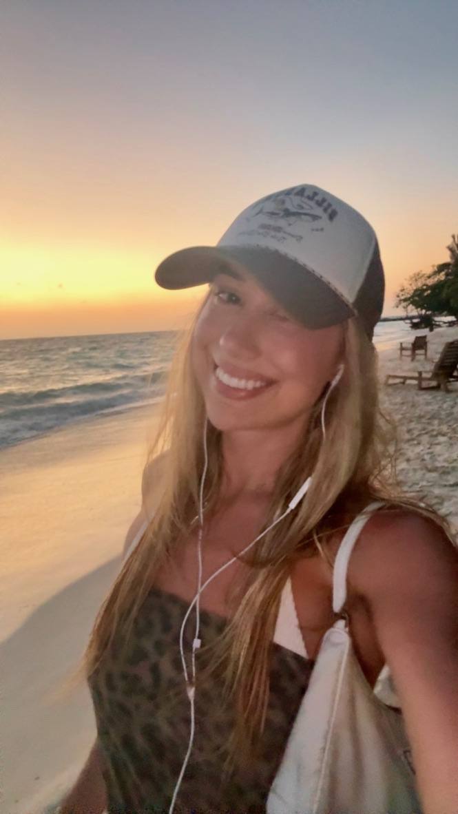 Sunset walk in a cap with earphones in
